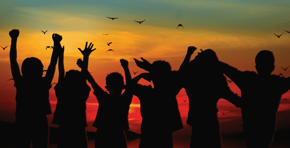 Silhouette of kids cheering in joy in a sunset