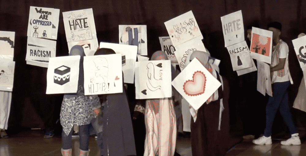 Islamic School kids hold up white signs with art on them