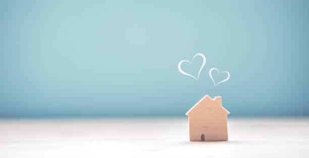 Home sweet home, house wood with heart shape on wooden and blue background