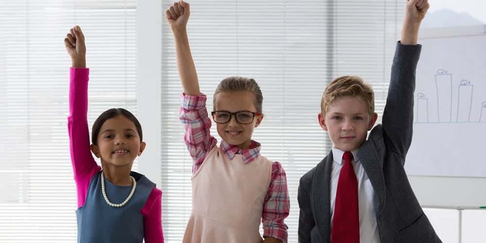 3 children with their fists up dressed as leaders