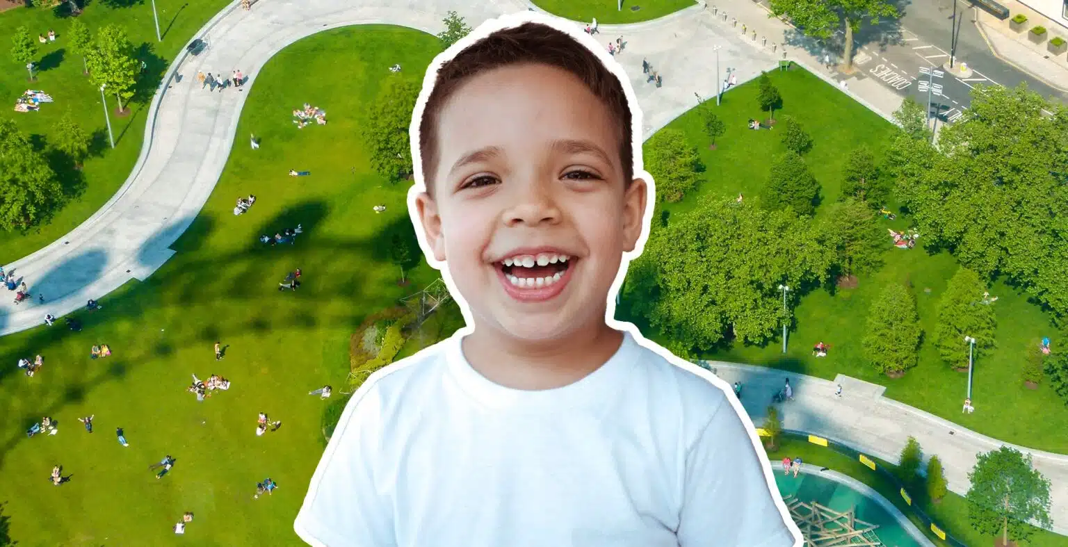 building. little boy laughing with a park in the background