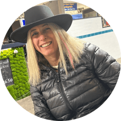 Irene Banchik smiles at camera wearing a hat and black jacket